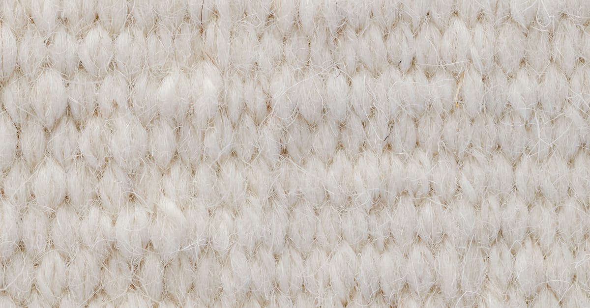 Detailed view of a beige wool textile fabric, showcasing its texture and softness.